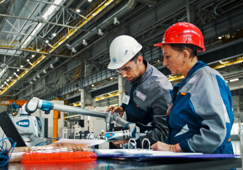 Manager in a manufacturing facility review equipment together, illustrating why managers don’t delegate when expertise feels tied to job security